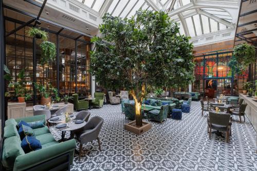 a lobby with a tree in the middle of a building at Kimpton Clocktower by IHG in Manchester