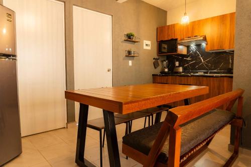 a kitchen with a wooden table and some chairs at 2 Bedrooms and Pool Acapulco Penthouse in Gallinero