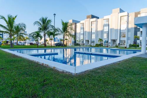 a swimming pool in front of a building with palm trees at 2 Bedrooms and Pool Acapulco Penthouse in Gallinero