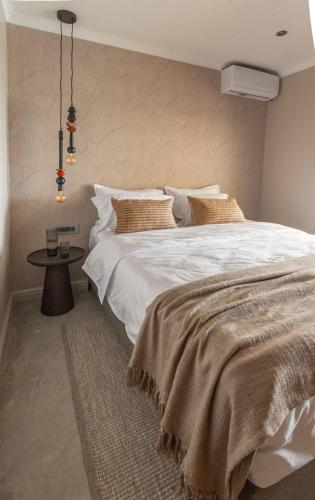 a bedroom with a large white bed and a table at Relax in Style at this Stunning Villa in Camps Bay, Cape Town in Cape Town