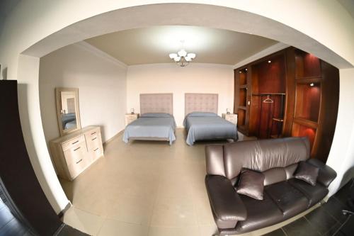 ein rundes Zimmer mit zwei Betten und einer Couch in der Unterkunft Spacious apartment for 2 people in Torreón
