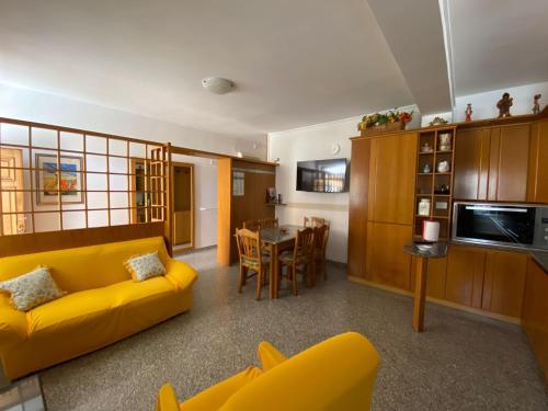 salon z żółtą kanapą i stołem w obiekcie La Rosa - Home Relax w Agropoli