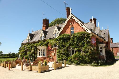 um velho edifício de tijolos com hera em The Red Lion em Revesby