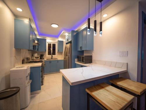 a kitchen with blue cabinets and a purple ceiling at Garden Condos 39, Luxury Apartment In Sosua Town in Sosúa