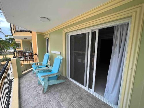 two blue chairs sitting on the balcony of a house at Garden Condos 39, Luxury Apartment In Sosua Town in Sosúa