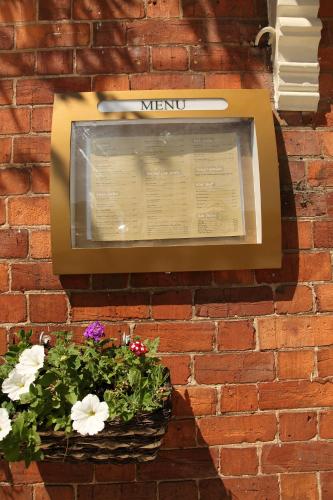 a sign on a brick wall with a basket of flowers at The Red Lion in Revesby