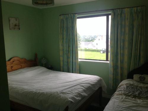 ein kleines Schlafzimmer mit einem Bett und einem Fenster in der Unterkunft Hill View B&B in Silvermines