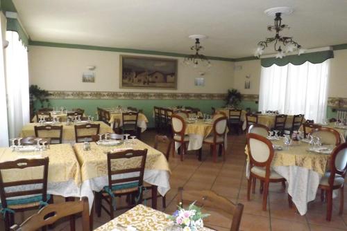 una sala da pranzo con tavoli e sedie in un ristorante di Il Campanile Hotel - La Cantina Del Pittore a Miazzina