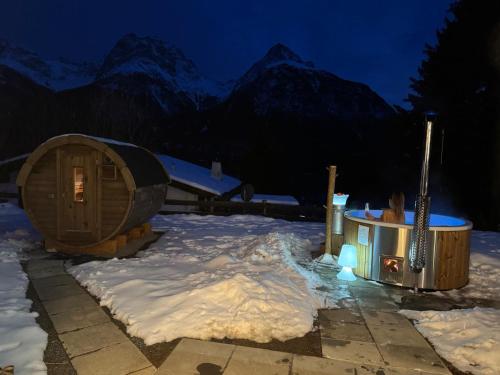 a cabin in the snow at night with mountains at Berg-Bijou Scuol in Scuol