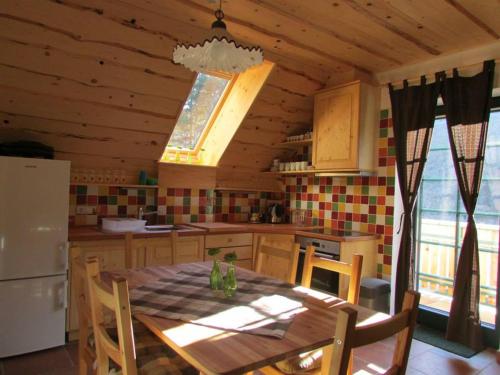 cocina con mesa de madera y cocina con nevera en Apartmaji Koželj, en Ribnica na Pohorju