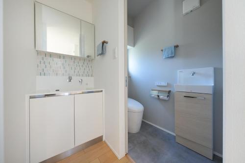 a white bathroom with a sink and a toilet at パーパスリゾート 越後湯沢 蔵 in Yuzawa
