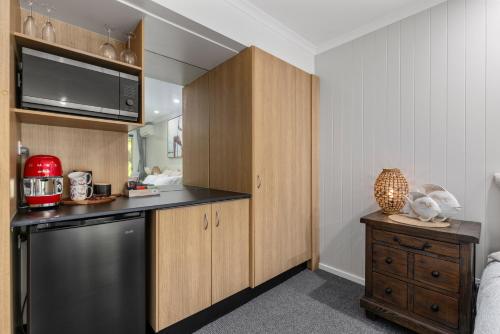 a kitchen with wooden cabinets and a dishwasher at Elvis - The Great Seaside Escape - Luxury Stay in Coffs Harbour