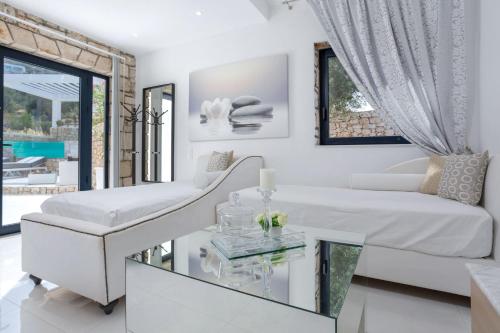 a living room with a white couch and a glass table at Dion Villa Zakynthos Greece One Bedroom Villa with Private Pool no01 in Agios Nikolaos