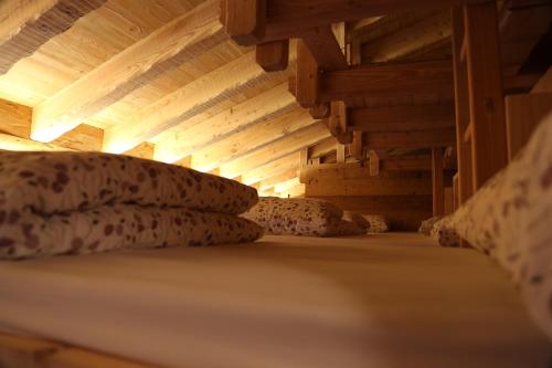 a bed with pillows in a room with wooden ceilings at Rifugio Luna Nascente in San Martino