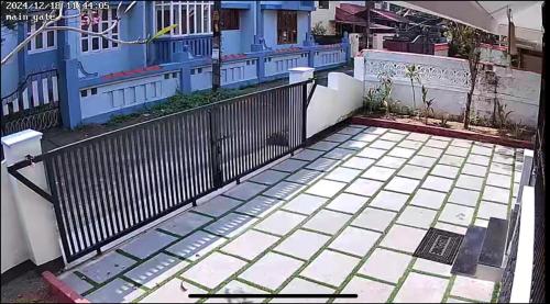 a fence in front of a blue house at Chitralayam Home stay in Guruvāyūr