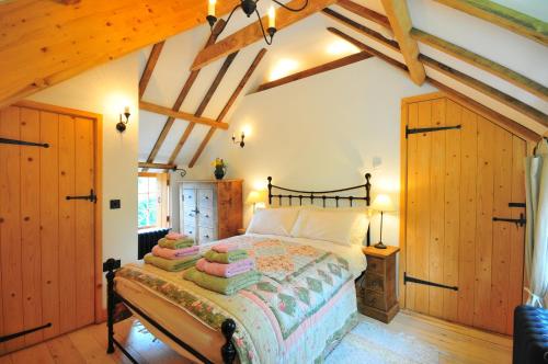Un dormitorio con una cama grande en una habitación con techos de madera. en Manor House Stables, Martin - lovely warm cosy accommodation near Woodhall Spa, en Martin