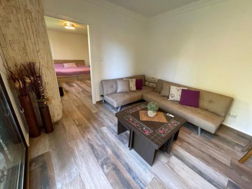 a living room with a couch and a table at Chalet in Batrouna Park resort, facing the pool, gazon,gym,GENERATOR IS INCLUDED in Al Ḩulwah