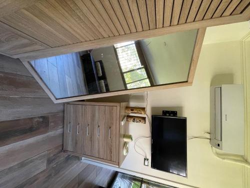 a small kitchen with a window and a refrigerator at Chalet in Batrouna Park resort, facing the pool, gazon,gym,GENERATOR IS INCLUDED in Al Ḩulwah