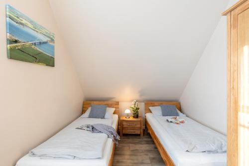 two beds in a small room with white walls at Ferienhaus Nelke in Fehmarn