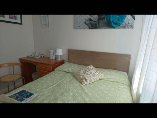 a bedroom with a bed with a pillow and a desk at Double Room private shower room - deg-yr in Hayes