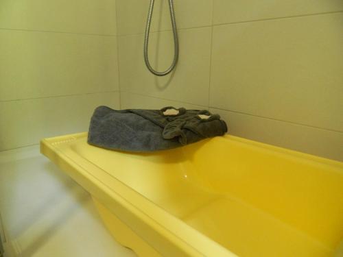 a bathroom with a yellow bath tub with a towel at Lago Maggiore Holiday House with Panoramic Views in Dumenza