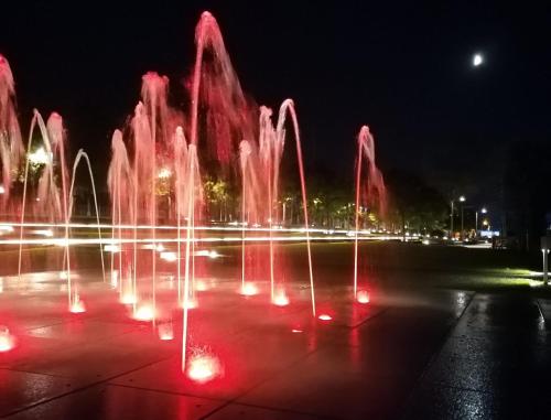 a fountain with red lights in a park at night at Lago Maggiore Holiday House with Panoramic Views in Dumenza