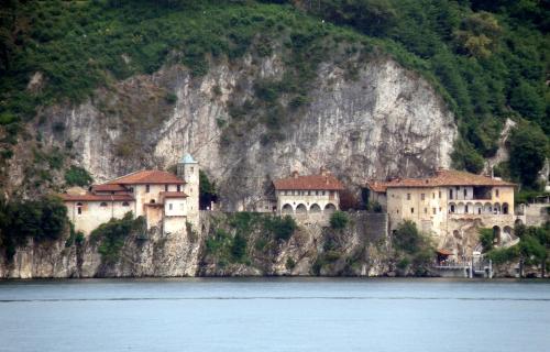 a building on the side of a mountain next to the water at Lago Maggiore Holiday House with Panoramic Views in Dumenza