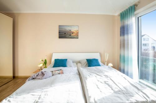 a bedroom with two beds and a large window at Bauernhof Lafrenz Wellness - Ferienhaus Ostküste in Fehmarn