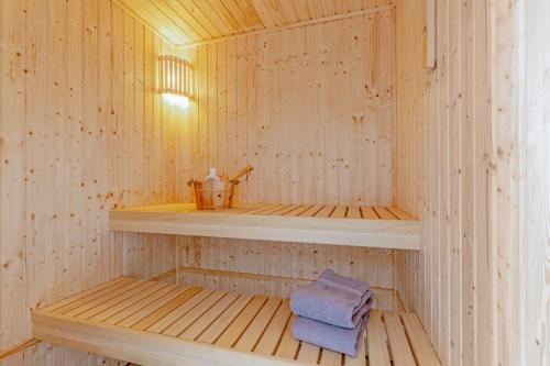 a wooden sauna with a towel on a shelf at Bauernhof Lafrenz Wellness - Ferienhaus Ostküste in Fehmarn