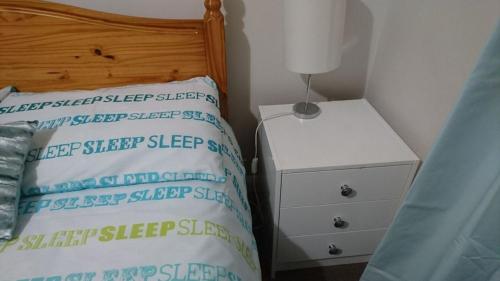a bedroom with a bed and a night stand with a lamp at En suite shower room Double room with 1 double deyr in Hayes