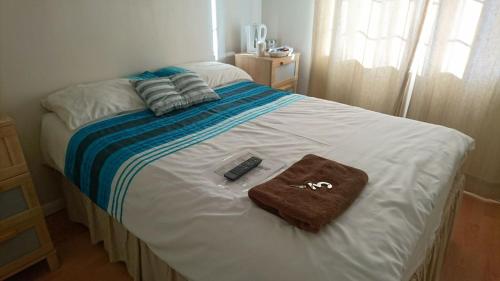 a bed with a remote control and a towel on it at En suite shower room Double room with 1 double deyr in Hayes