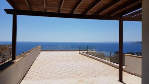 a large balcony with a view of the ocean at Palazzo De Donno App no04 in Santa Cesarea Terme