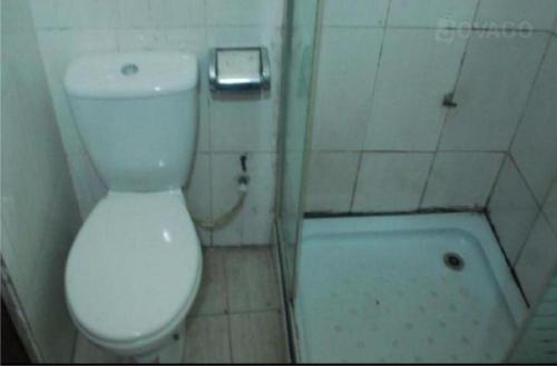 a small bathroom with a toilet and a bath tub at Christine Hotel - Christine Monarch in Port Harcourt