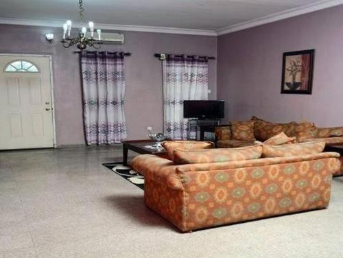a living room with two couches and a tv at Christine Hotel - Christine Monarch in Port Harcourt