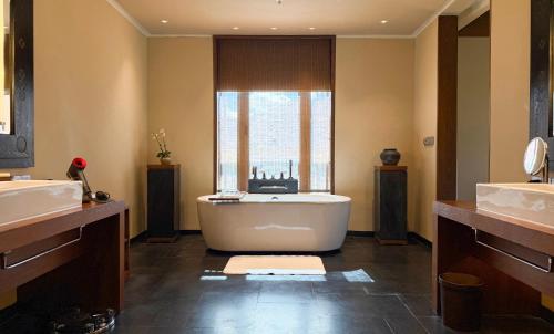 a bathroom with a tub and two sinks and a window at The St. Regis Lhasa Resort in Lhasa