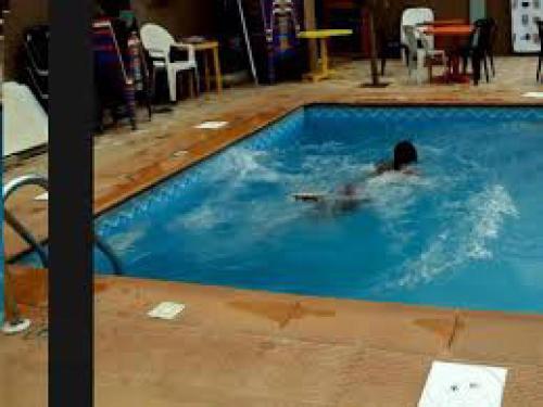 a person in a swimming pool with a frisbee at Hi Point Hotel and Suites - Deluxe in Lagos