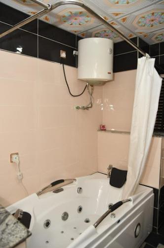 a bath tub in a bathroom with a ceiling at Choice Gate Hotel - Presidential Suite in Benin City