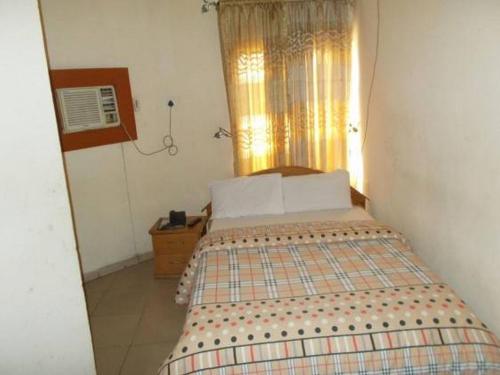 a small bedroom with a bed with a window at Bahamas Hotels International in Abuja