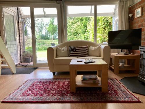 a living room with a couch and a tv at Holiday house Viktoria at lake Lauwersmeer in Anjum