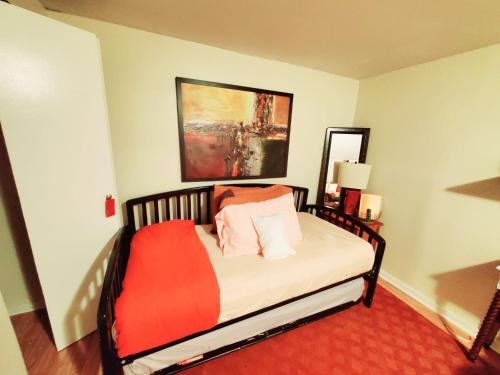 a bedroom with a bed with a red blanket on it at Fall Room 3min From Yale, And Other Colleges in New Haven