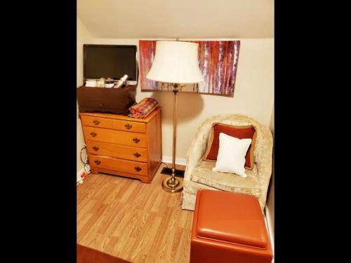 a living room with a chair with a pillow on it at Fall Room 3min From Yale, And Other Colleges in New Haven