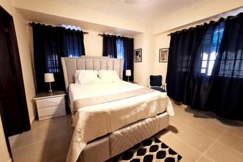 - une chambre avec un grand lit et des rideaux noirs dans l'établissement Goistay Descubre el Encanto nico de Repblica Dominicana Bella Vista, à Los Prados