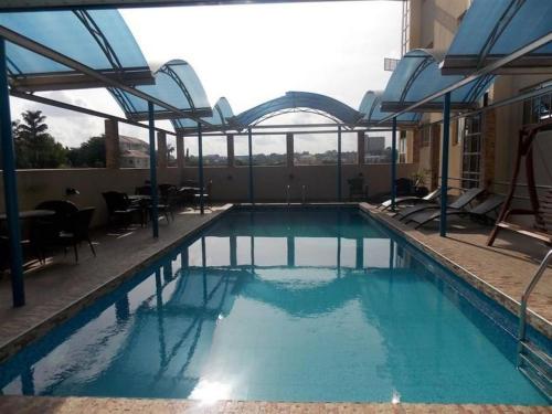 a swimming pool with blue water in a building at Ayalla Hotel Suites-yenogoa Royal Room in Port Harcourt