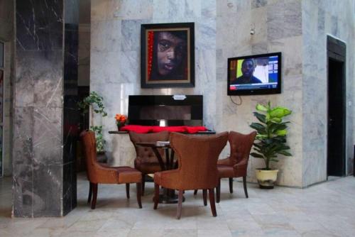 a dining room with a table and chairs and a tv at New Blue Diamond Hotel - rosebud in Jabi