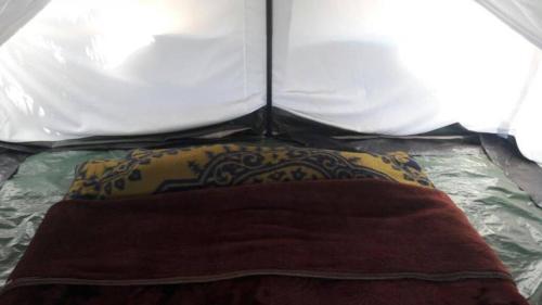 um travesseiro em uma cama em uma barraca em Swiss Tents in Ooty, Tn em Ooty