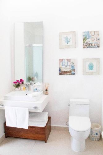 a bathroom with a sink and a toilet and a mirror at New beautiful house in El Tigre, Golf Club, Punta Cala 205 in Nuevo Vallarta