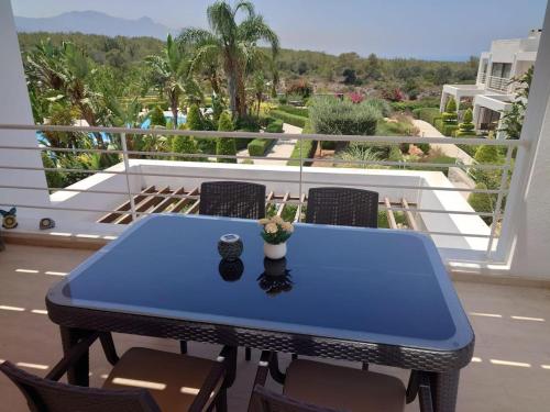 a blue table on a balcony with chairs at Penthouse Apartment with Stunning Sea and Mountain Views in Ayios Yeoryios