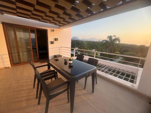 a table and chairs on a balcony with a view at Penthouse Apartment with Stunning Sea and Mountain Views in Ayios Yeoryios