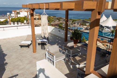 a balcony with a view of a pool and the ocean at Luxurious Seafront Penthouse in Kérynia