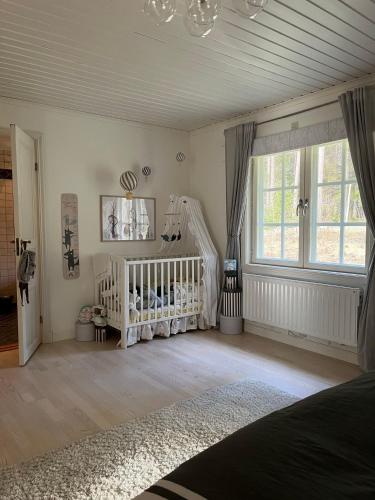 a baby room with a crib and a crib at Charming property with private pool in Märsta